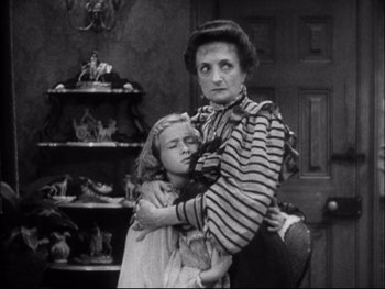 Movie still from “Cavalcade” (1933), directed by Frank Lloyd – An old photo of a woman and a young girl hugging; Medium shot, High angle