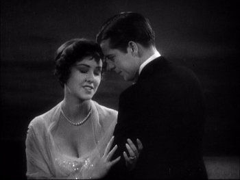Movie still from “Cavalcade” (1933), directed by Frank Lloyd – A man and a woman standing next to each other; Medium shot, Low angle
