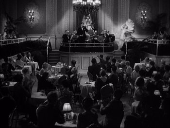 Movie still from “Cavalcade” (1933), directed by Frank Lloyd – An old photo of people sitting at tables in a room; Extreme Wide shot, High angle