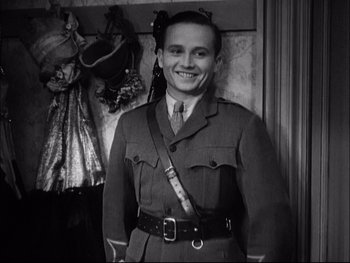 Movie still from “Cavalcade” (1933), directed by Frank Lloyd – A man in a military uniform smiling for the camera; Medium shot, Low angle
