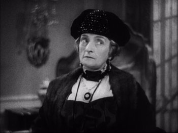 Movie still from “Cavalcade” (1933), directed by Frank Lloyd – An older woman wearing a black hat and a black dress; Close Up shot, High angle