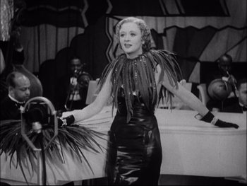 Movie still from “Cavalcade” (1933), directed by Frank Lloyd – A black and white photo of a woman in a black dress; Medium shot, Low angle