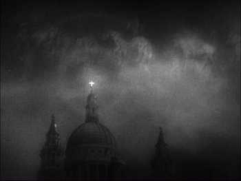 Movie still from “Cavalcade” (1933), directed by Frank Lloyd – A black and white photo of a cross on top of a building; Extreme Wide shot, Low angle