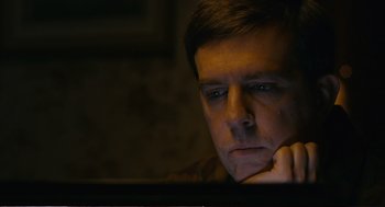 Movie still from “Cedar Rapids” (2011), directed by Miguel Arteta – A man sitting in front of a computer screen; Close Up shot, Low angle