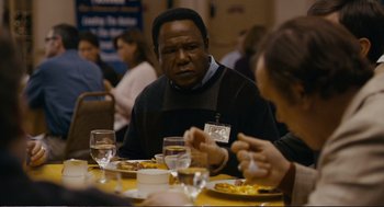 Movie still from “Cedar Rapids” (2011), directed by Miguel Arteta – A group of people sitting at a table eating food; Close Up shot, Over the shoulder angle