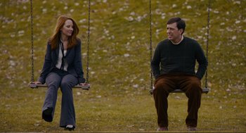Movie still from “Cedar Rapids” (2011), directed by Miguel Arteta – A man and a woman sitting on a swing; Wide shot, Over the shoulder angle