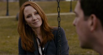 Movie still from “Cedar Rapids” (2011), directed by Miguel Arteta – A woman sitting on top of a metal swing; Close Up shot, Over the shoulder angle