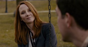 Movie still from “Cedar Rapids” (2011), directed by Miguel Arteta – A woman sitting on top of a swing looking at a man; Close Up shot, Over the shoulder angle