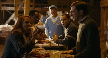 Movie still from “Cedar Rapids” (2011), directed by Miguel Arteta – A group of people sitting at a table eating food; Medium shot, Over the shoulder angle