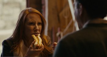Movie still from “Cedar Rapids” (2011), directed by Miguel Arteta – A woman is eating a banana while a man watches; Close Up shot, Over the shoulder angle