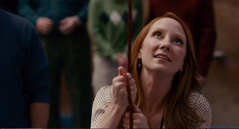 Movie still from “Cedar Rapids” (2011), directed by Miguel Arteta – A red haired woman holding onto a brown rope; Close Up shot, Low angle