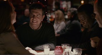 Movie still from “Cedar Rapids” (2011), directed by Miguel Arteta – A man sitting at a table with a glass of wine; Medium shot, Over the shoulder angle
