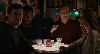 Movie still from “Cedar Rapids” (2011), directed by Miguel Arteta – A group of men sitting at a table with drinks; Medium shot, Over the shoulder angle