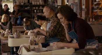 Movie still from “Cedar Rapids” (2011), directed by Miguel Arteta – A group of people sitting at a table preparing food; Medium shot, Over the shoulder angle