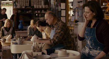 Movie still from “Cedar Rapids” (2011), directed by Miguel Arteta – A group of people sitting at a table in a room; Medium shot, Over the shoulder angle