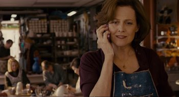 Movie still from “Cedar Rapids” (2011), directed by Miguel Arteta – A woman talking on a cell phone while sitting in a kitchen; Close Up shot, Over the shoulder angle
