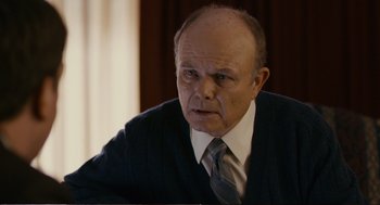 Movie still from “Cedar Rapids” (2011), directed by Miguel Arteta – An older man wearing a suit and tie; Close Up shot, Over the shoulder angle