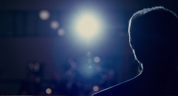 Movie still from “Cedar Rapids” (2011), directed by Miguel Arteta – A man standing in front of a bright light; Close Up shot, Over the shoulder angle