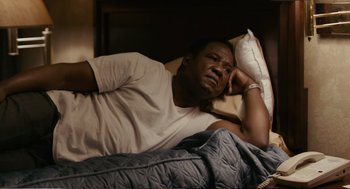 Movie still from “Cedar Rapids” (2011), directed by Miguel Arteta – A man laying in bed with his head on a pillow; Medium shot, High angle