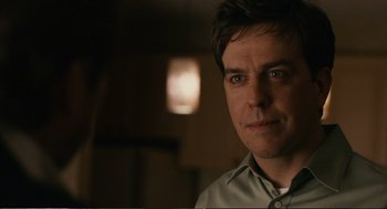 Movie still from “Cedar Rapids” (2011), directed by Miguel Arteta – A person wearing a button up shirt; Close Up shot, Over the shoulder angle