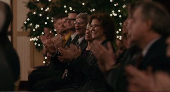Movie still from “Cedar Rapids” (2011), directed by Miguel Arteta – A group of people sitting next to each other clapping; Medium shot, Over the shoulder angle