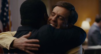 Movie still from “Cedar Rapids” (2011), directed by Miguel Arteta – A man hugging another man in a room; Close Up shot, Over the shoulder angle