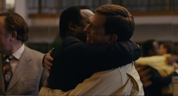 Movie still from “Cedar Rapids” (2011), directed by Miguel Arteta – A couple of men hugging each other in a room; Close Up shot, Over the shoulder angle