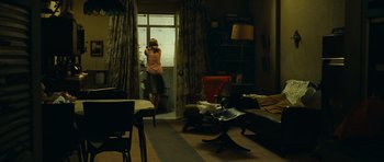 Movie still from “Central Station” (1998), directed by Walter Salles – A woman standing in front of a window in a living room; Wide shot, Over the shoulder angle