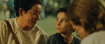 Movie still from “Central Station” (1998), directed by Walter Salles – A woman sitting next to a young boy in a room; Close Up shot, Over the shoulder angle