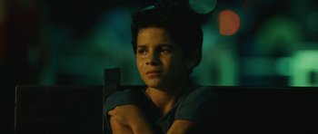 Movie still from “Central Station” (1998), directed by Walter Salles – A young boy sitting in a chair with his arms crossed; Close Up shot, High angle