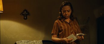 Movie still from “Central Station” (1998), directed by Walter Salles – A woman holding an envelope in her hands; Medium shot, Over the shoulder angle