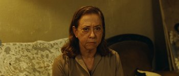 Movie still from “Central Station” (1998), directed by Walter Salles – An older woman sitting in front of a couch; Close Up shot, High angle