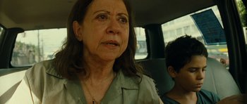 Movie still from “Central Station” (1998), directed by Walter Salles – An older woman sitting in the back seat of a car; Close Up shot, Over the shoulder angle