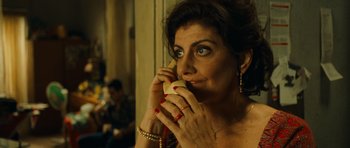 Movie still from “Central Station” (1998), directed by Walter Salles – A woman holding a sandwich in front of her face; Close Up shot, Over the shoulder angle