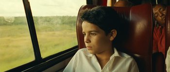 Movie still from “Central Station” (1998), directed by Walter Salles – A young boy sitting on a train looking out the window; Close Up shot, Low angle