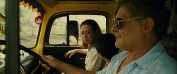 Movie still from “Central Station” (1998), directed by Walter Salles – A man and a woman driving a car in the road; Close Up shot, Over the shoulder angle
