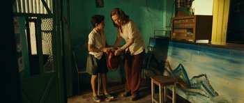 Movie still from “Central Station” (1998), directed by Walter Salles – A woman helping a boy put on a backpack; Medium shot, High angle