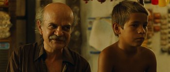 Movie still from “Central Station” (1998), directed by Walter Salles – An older man and a young boy are looking at each other; Close Up shot, Over the shoulder angle