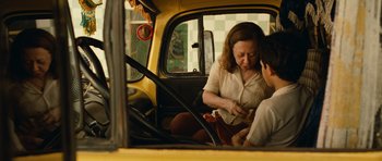 Movie still from “Central Station” (1998), directed by Walter Salles – A woman sitting in the passenger seat of a yellow bus; Medium shot, Over the shoulder angle