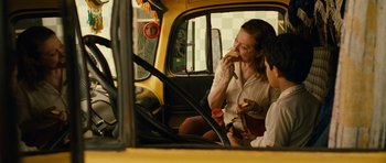 Movie still from “Central Station” (1998), directed by Walter Salles – A woman sitting in the passenger seat of a yellow bus; Medium shot, Over the shoulder angle