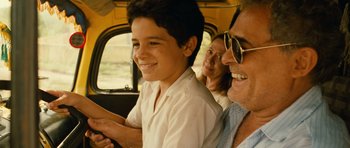 Movie still from “Central Station” (1998), directed by Walter Salles – A young boy sitting in the driver's seat of a car with an older woman and a younger man; Close Up shot, Over the shoulder angle