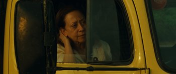 Movie still from “Central Station” (1998), directed by Walter Salles – An older woman sitting in the driver's seat of a yellow bus; Close Up shot, Over the shoulder angle