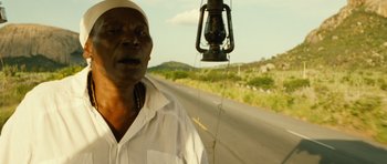 Movie still from “Central Station” (1998), directed by Walter Salles – A man standing on the side of a road next to a street light; Close Up shot, Low angle