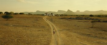 Movie still from “Central Station” (1998), directed by Walter Salles – A dirt road leading to a house in the middle of a desert; Extreme Wide shot, High angle