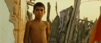 Movie still from “Central Station” (1998), directed by Walter Salles – A young boy standing in front of a wooden structure; Close Up shot, Low angle