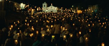 Movie still from “Central Station” (1998), directed by Walter Salles – A group of people sitting in front of a building at night; Extreme Wide shot, High angle