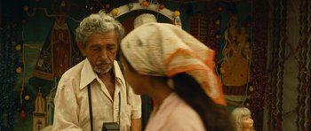 Movie still from “Central Station” (1998), directed by Walter Salles – An older man and a woman in a market; Close Up shot, Over the shoulder angle