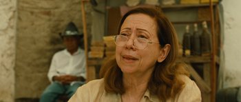 Movie still from “Central Station” (1998), directed by Walter Salles – An older woman wearing glasses and a tan shirt; Close Up shot, Over the shoulder angle
