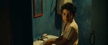 Movie still from “Central Station” (1998), directed by Walter Salles – A young boy sitting at a sink in a bathroom; Close Up shot, Over the shoulder angle
