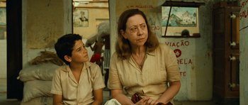 Movie still from “Central Station” (1998), directed by Walter Salles – A woman sitting next to a young boy in front of a building; Close Up shot, Over the shoulder angle
